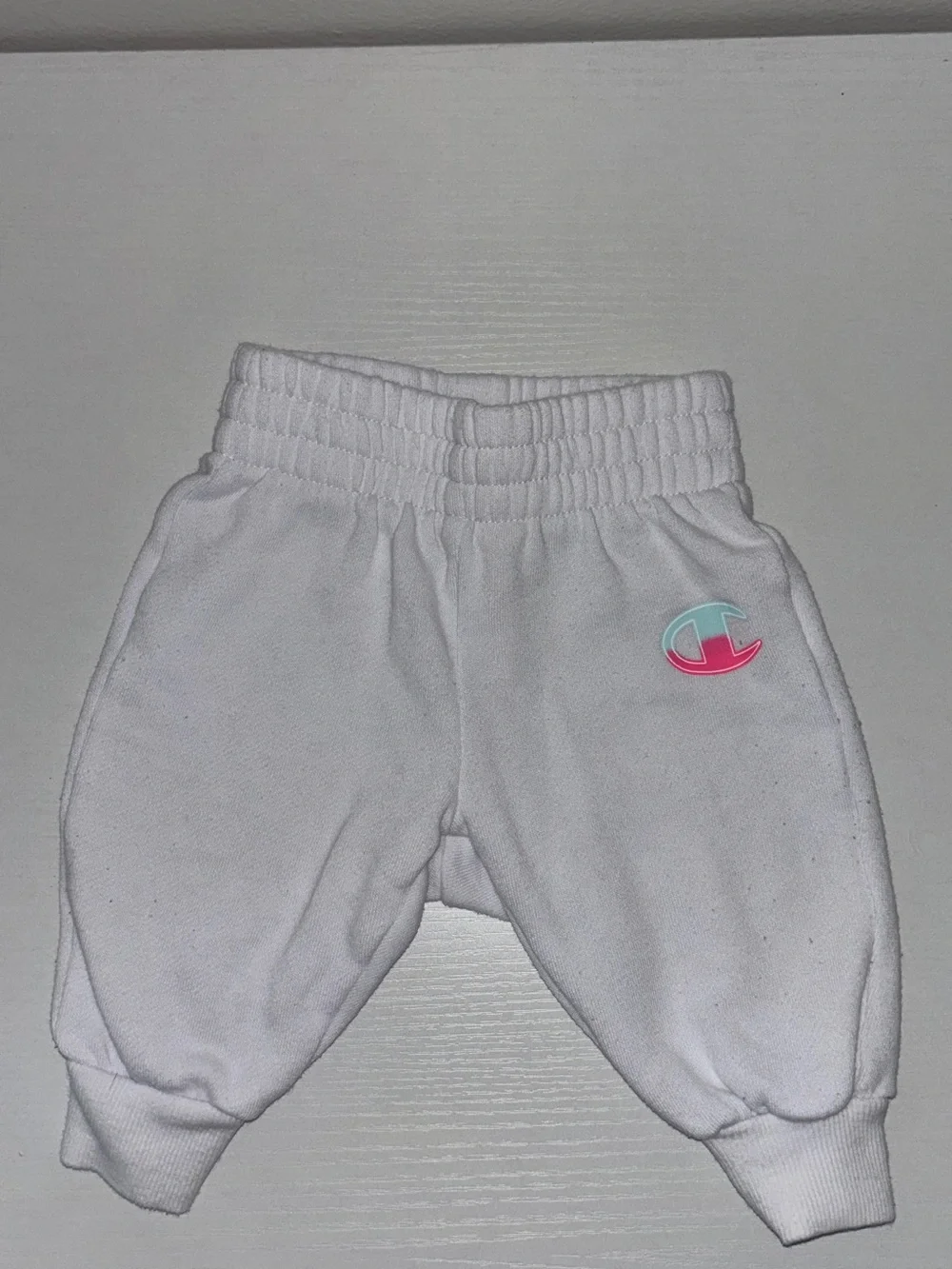 Champion: White Baby Sweatpants with Pink & Teal Logo Patch